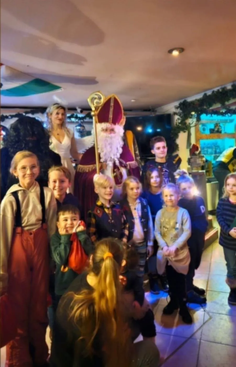 Nikolaus und Knecht Ruprecht posieren gemeinsam mit einer Gruppe Kinder bei einem Auftritt in Augsburg