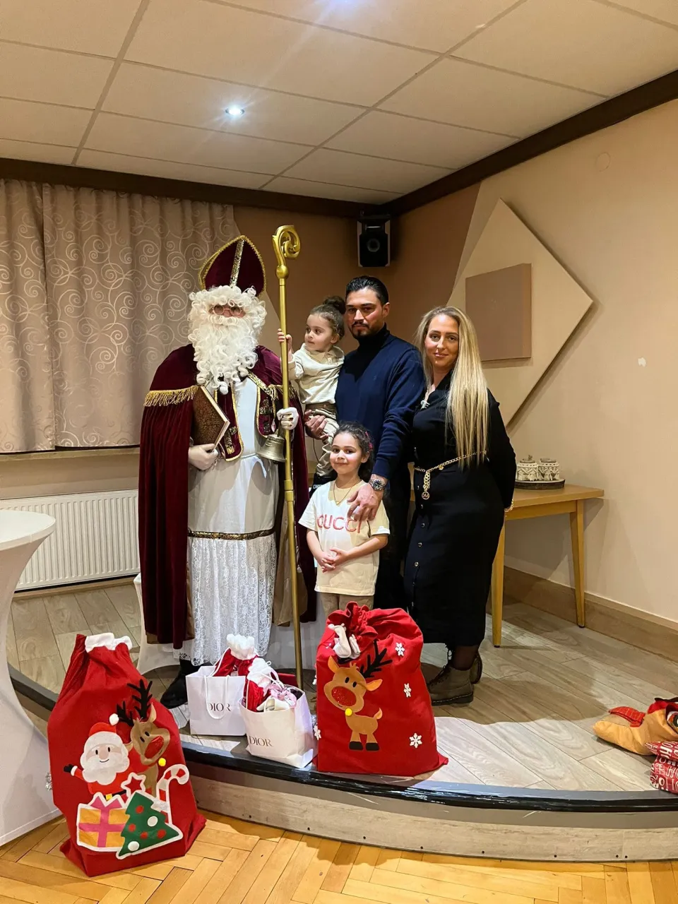 Nikolaus auf der Bühne mit einer Familie und vielen Geschenken bei einer Vereinsfeier.