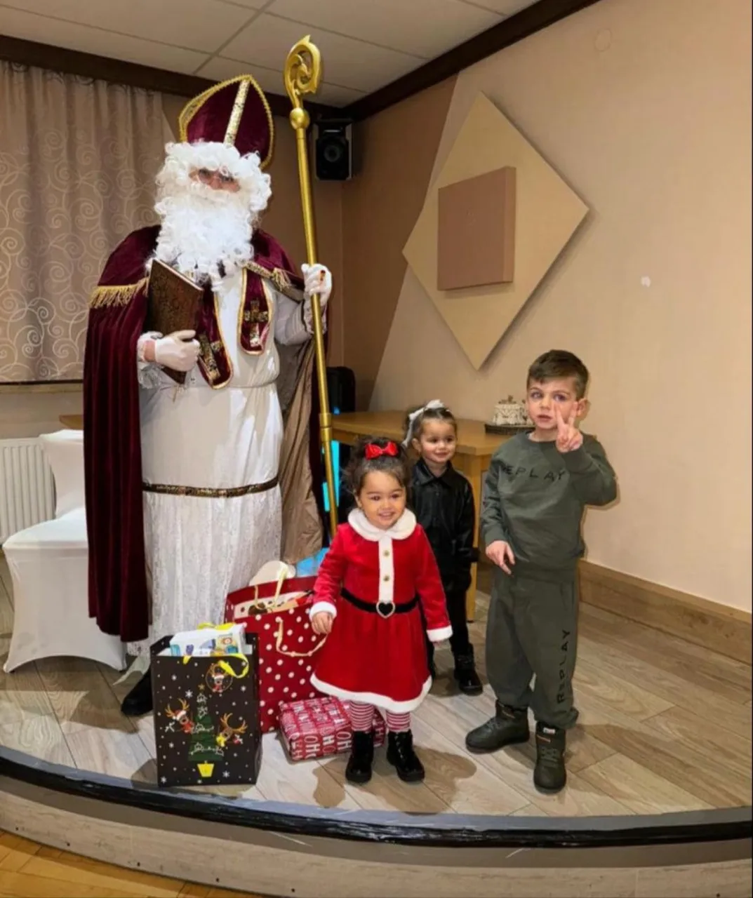 Nikolaus mit drei Kindern auf der Bühne bei einer Vereinsfeier.