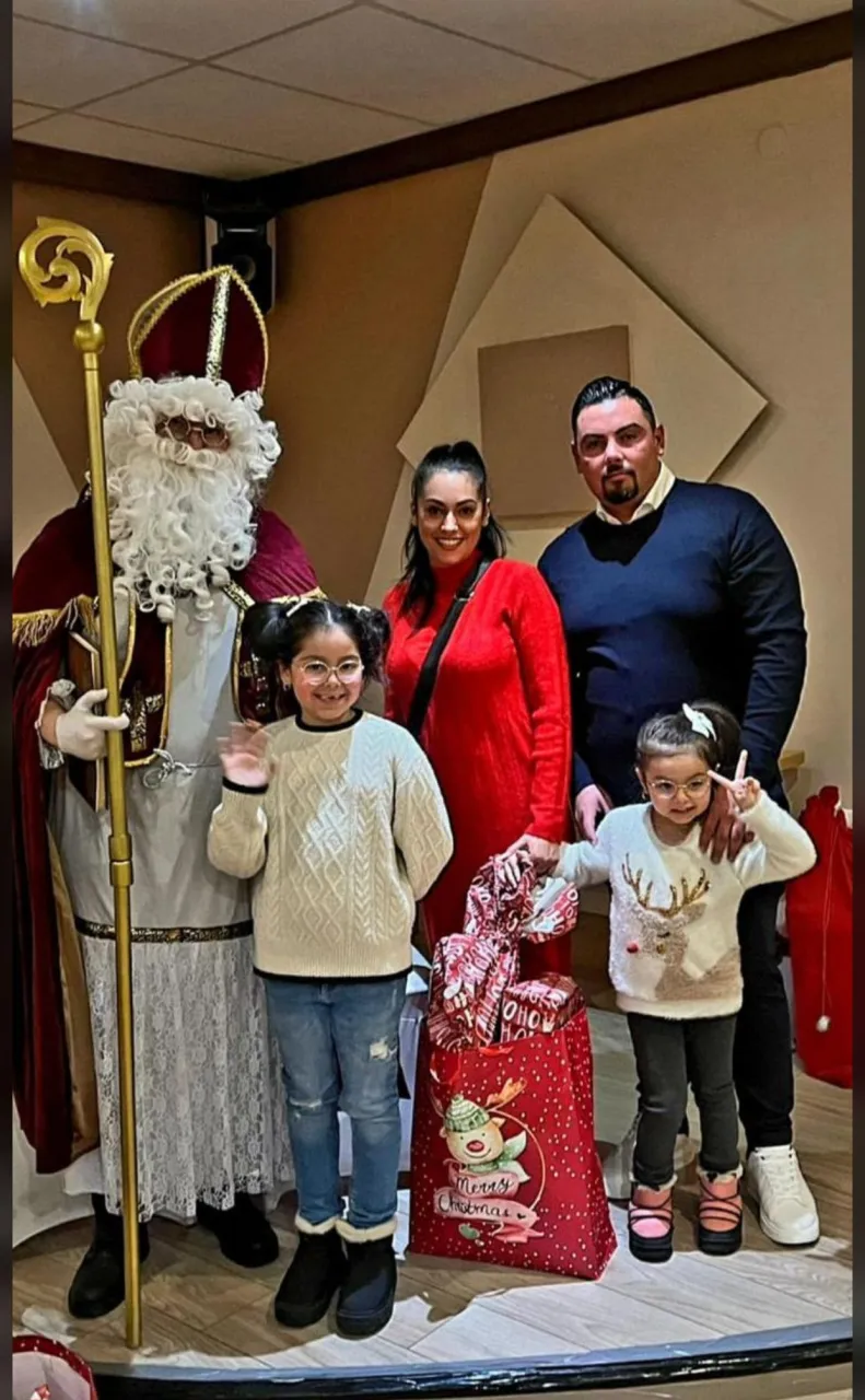 Nikolaus mit einer Familie mit zwei Kindern und ihren Geschenken bei einer Vereinsfeier.