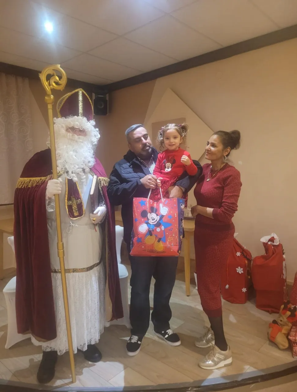 Nikolaus mit einer Familie und ihren Geschenken bei einer Vereinsfeier.