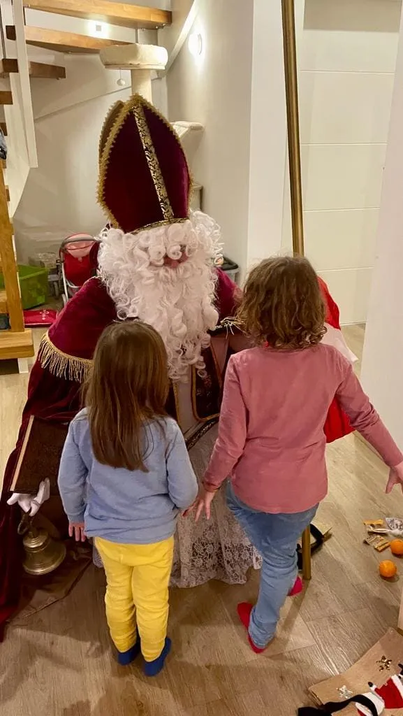 Nikolaus mit zwei kleinen Mädchen auf Augenhöhe.