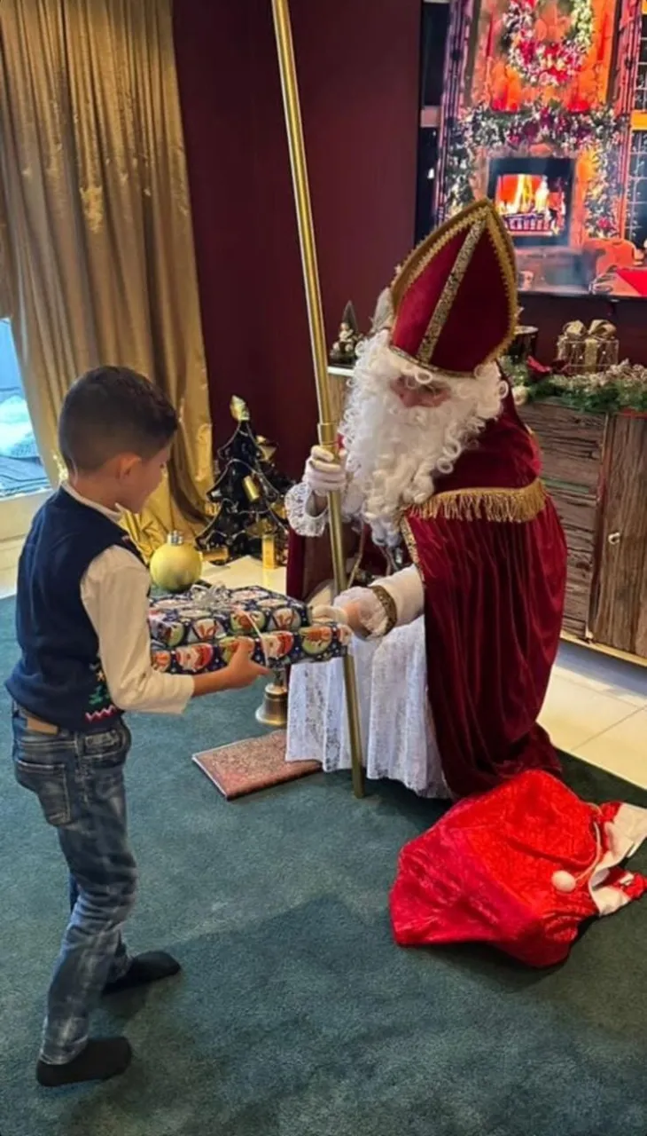 Nikolaus überreicht schön verpackte Geschenke an einen kleinen Jungen.