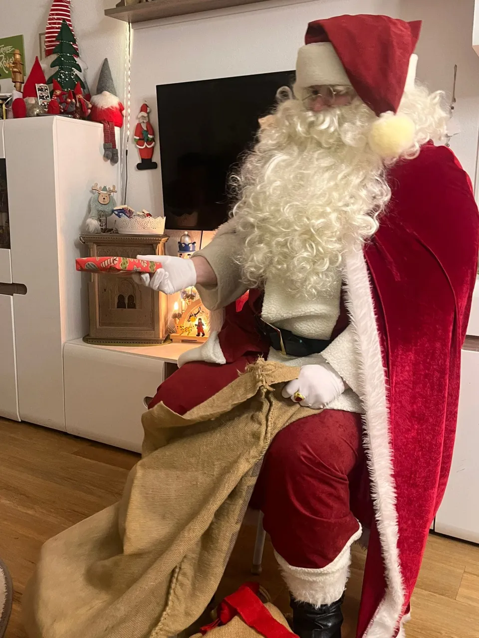 Aufnahme vom Weihnachtsmann wie er ein Geschenk überreicht.