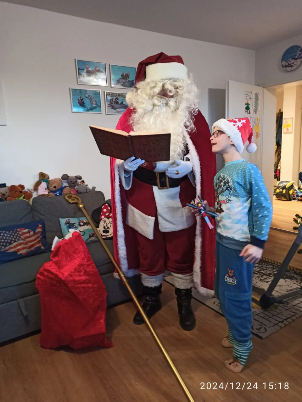 Ein Junge liest im goldenen Buch zusammen mit dem Weihnachtsmann.