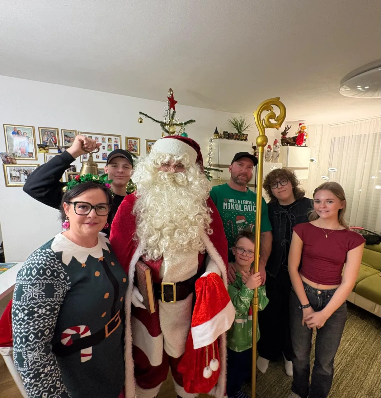 Gruppenfoto vom Weihnachtsmann mit einer Familie mit Mama, Papa, Schwestern und Söhnen, der Kleinste hält den Stab vom Weihnachtsmann.