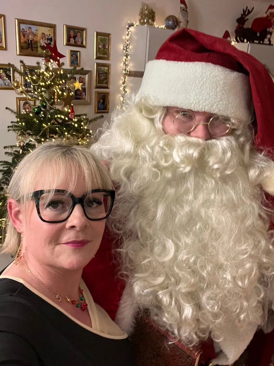 Selfie vom Weihnachtsmann und einer gut gekleideten Frau.