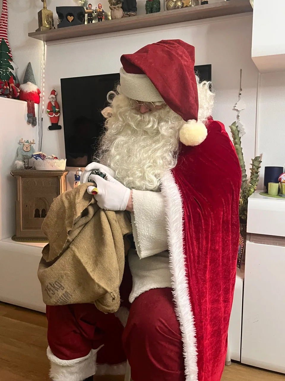 Weihnachtsmann sucht nach Geschenken in seinem Sack.