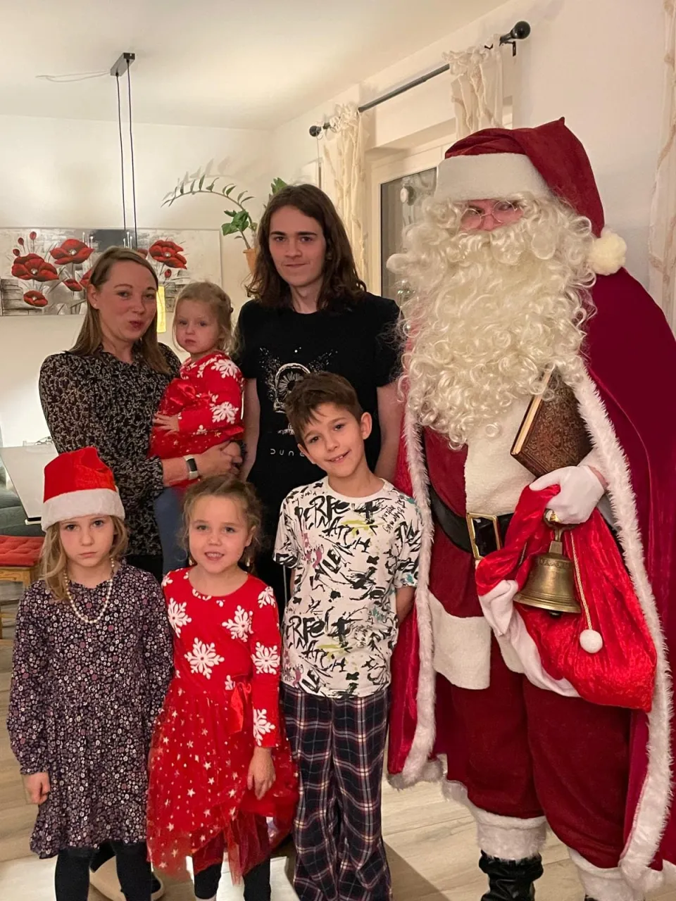 Weihnachtsmann und mehrere Kinder zusammen.