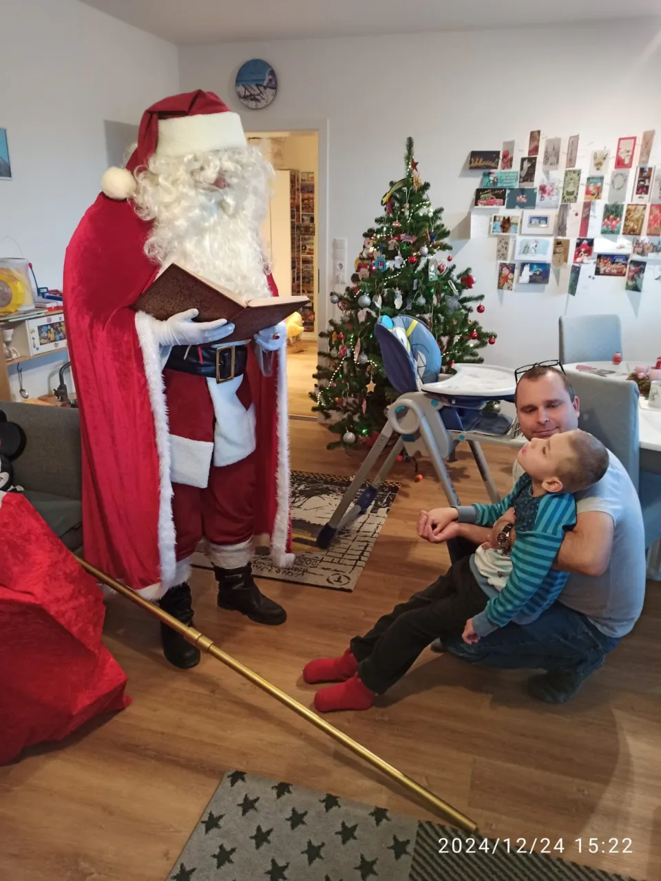 Weihnachtsmann unterhält sich mit einem Kind.