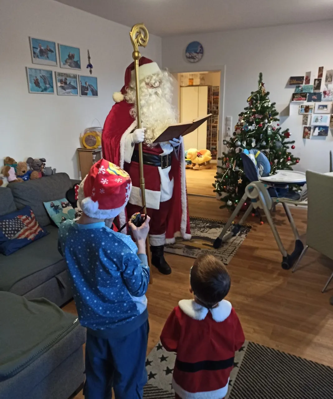 Zwei Kinder lauschen gespannt den Worten vom Weihnachtsmann.