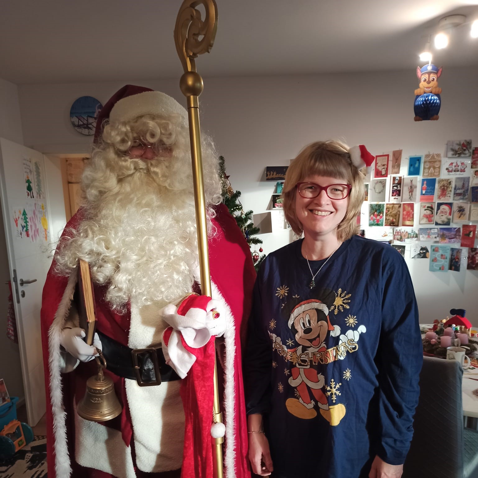 Weihnachtsmann bei einem persönlichen Besuch mit einer Frau Weihnachtsmann steht neben einer lächelnden Frau bei einem persönlichen Besuch