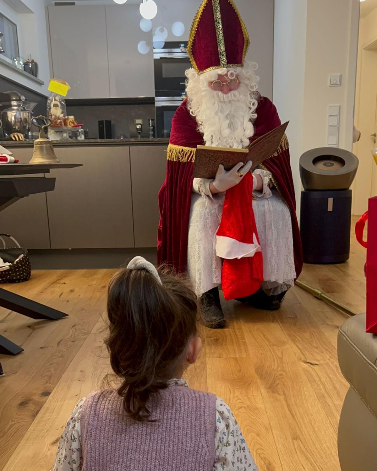 Nikolaus im Gespräch mit einem Mädchen Ein kleines Mädchen sitzt vor dem Nikolaus und lauscht gespannt seinen Worten