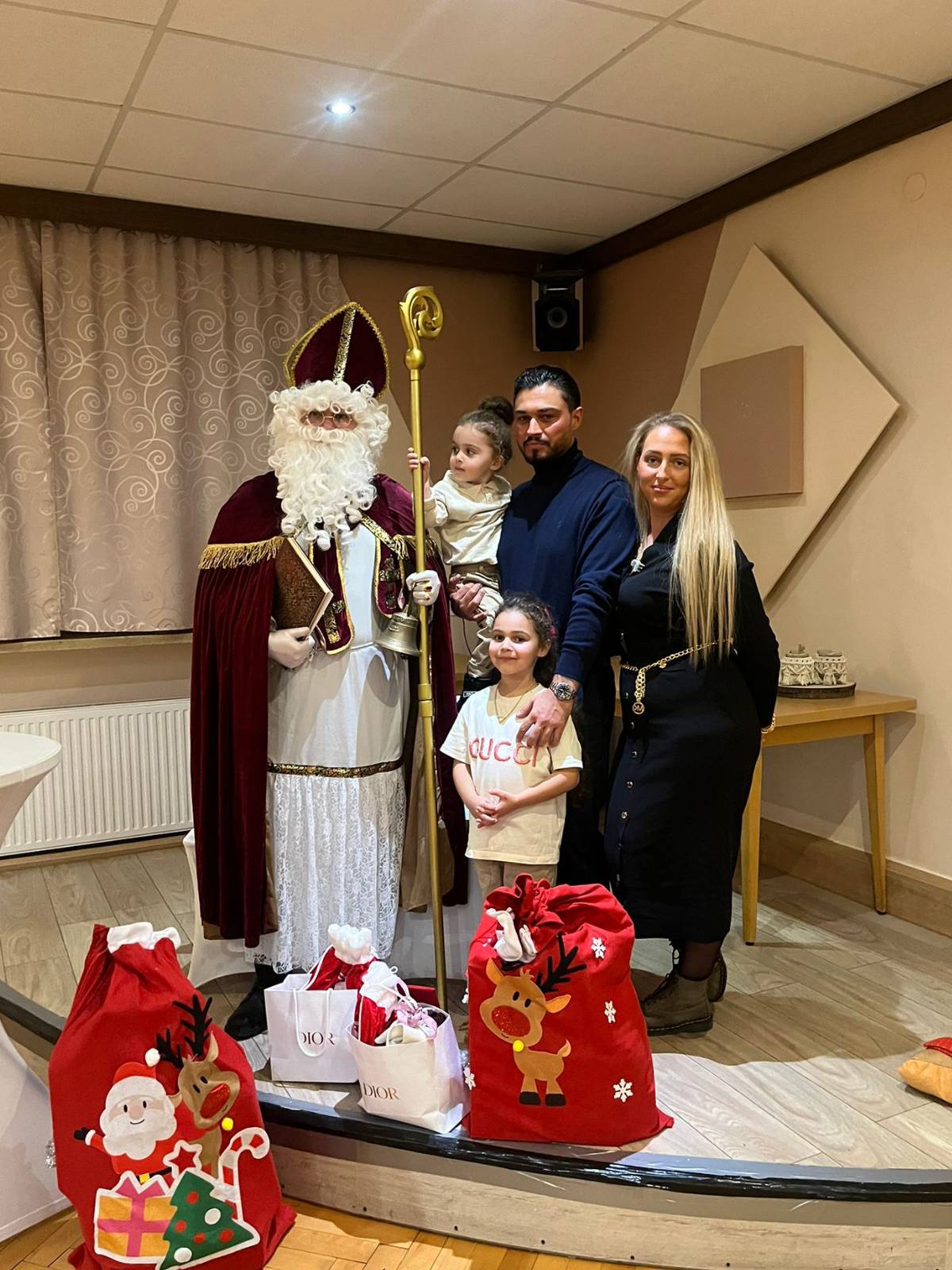 Nikolaus bei einem Bühnenauftritt im Rahmen einer Veranstaltung Nikolaus auf einer Bühne mit einer Familie und vielen Geschenken