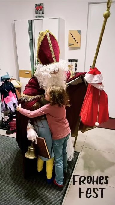 Nikolaus begrüßt Kinder in Augsburg mit einer herzlichen Umarmung bei seinem Auftritt
