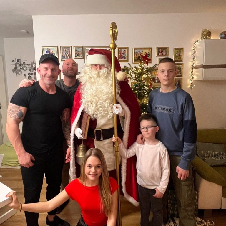 Nikolaus und Weihnachtsmann in Augsburg posiert mit einer Familie bei einem unvergesslichen Auftritt auf einer Feier